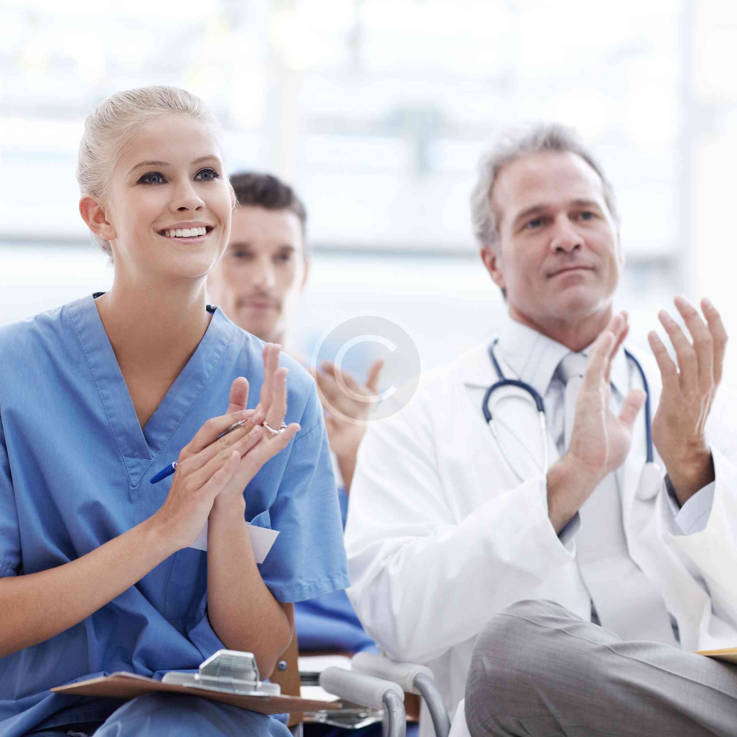 Medical professionals clapping in a conference.