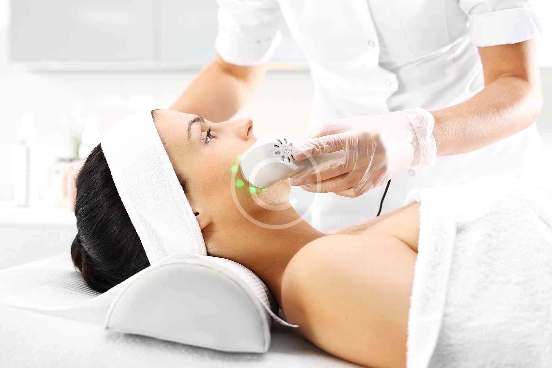 Woman receiving facial treatment in spa.